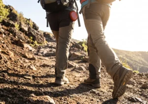 Dynamic morning hike on rugged trail, showing a person with steady endurance carrying polished Red Jasper.